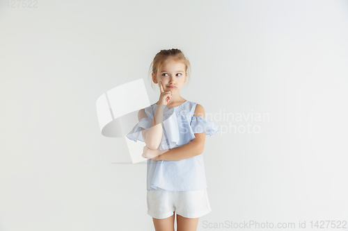 Image of Little smiling girl posing in casual clothes on white studio background
