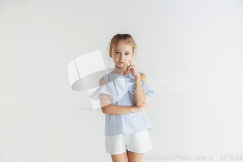 Image of Little smiling girl posing in casual clothes on white studio background