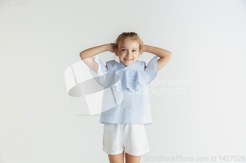 Image of Little smiling girl posing in casual clothes on white studio background