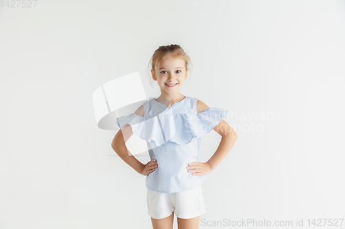 Image of Little smiling girl posing in casual clothes on white studio background