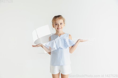 Image of Little smiling girl posing in casual clothes on white studio background