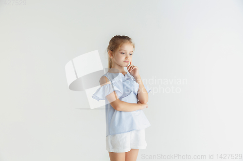 Image of Little smiling girl posing in casual clothes on white studio background