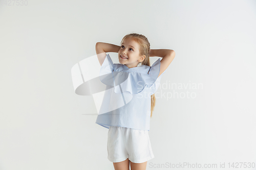 Image of Little smiling girl posing in casual clothes on white studio background