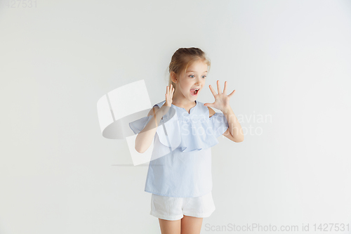 Image of Little smiling girl posing in casual clothes on white studio background
