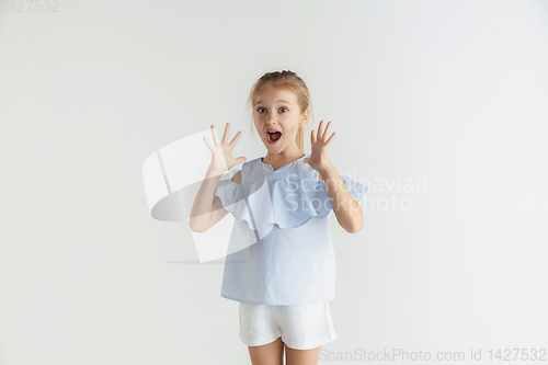 Image of Little smiling girl posing in casual clothes on white studio background
