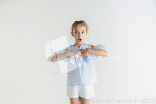 Image of Little smiling girl posing in casual clothes on white studio background