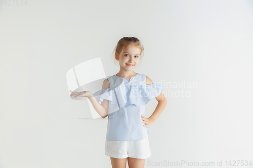 Image of Little smiling girl posing in casual clothes on white studio background