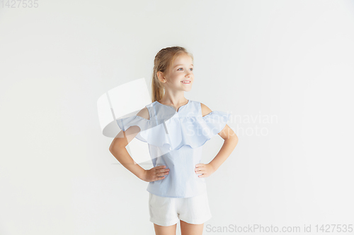 Image of Little smiling girl posing in casual clothes on white studio background