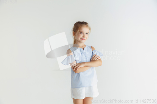 Image of Little smiling girl posing in casual clothes on white studio background