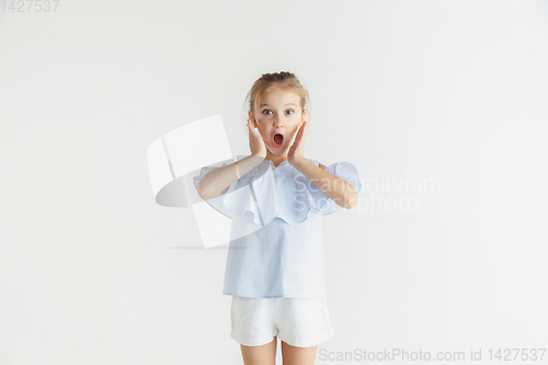 Image of Little smiling girl posing in casual clothes on white studio background