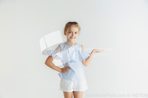 Image of Little smiling girl posing in casual clothes on white studio background