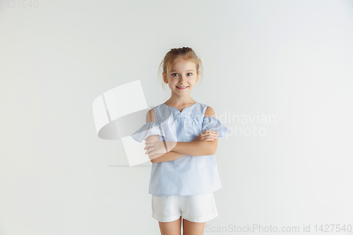 Image of Little smiling girl posing in casual clothes on white studio background