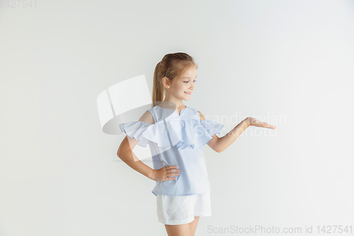 Image of Little smiling girl posing in casual clothes on white studio background