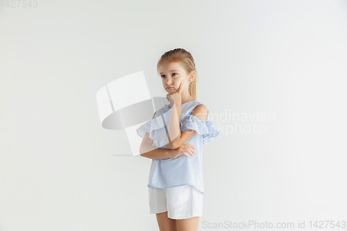 Image of Little smiling girl posing in casual clothes on white studio background