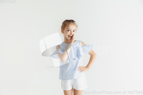 Image of Little smiling girl posing in casual clothes on white studio background
