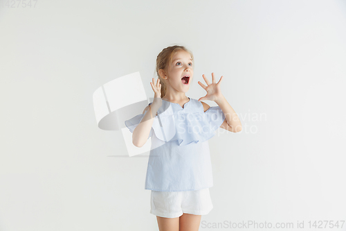 Image of Little smiling girl posing in casual clothes on white studio background