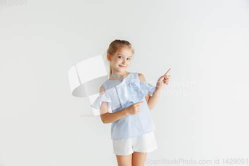Image of Little smiling girl posing in casual clothes on white studio background
