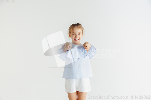 Image of Little smiling girl posing in casual clothes on white studio background