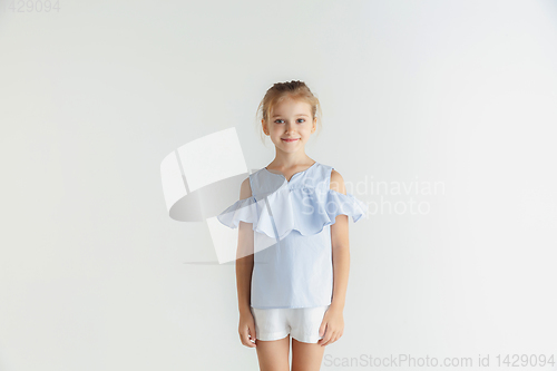 Image of Little smiling girl posing in casual clothes on white studio background