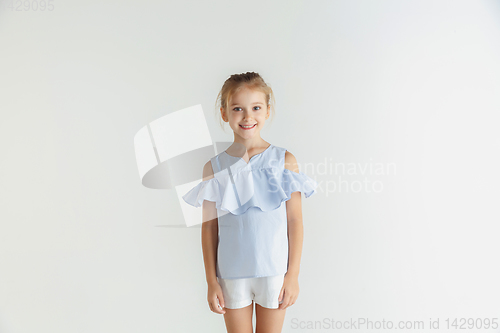Image of Little smiling girl posing in casual clothes on white studio background