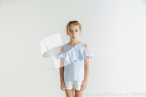 Image of Little smiling girl posing in casual clothes on white studio background