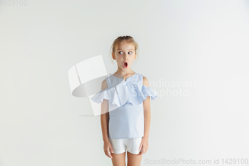 Image of Little smiling girl posing in casual clothes on white studio background