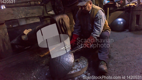 Image of blacksmith workers using mechanical hammer at workshop