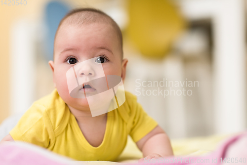 Image of newborn baby boy playing on the floor