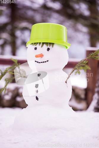 Image of smiling snowman with green hat