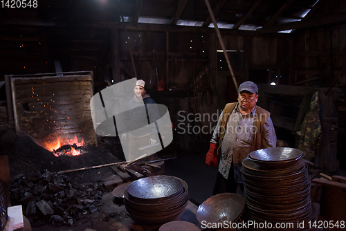 Image of portrait of two generations traditional blacksmith