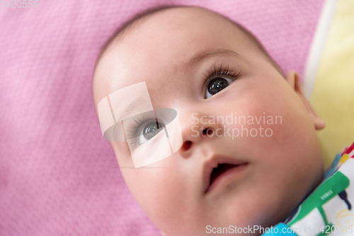 Image of top view of newborn baby boy lying on colorful blankets