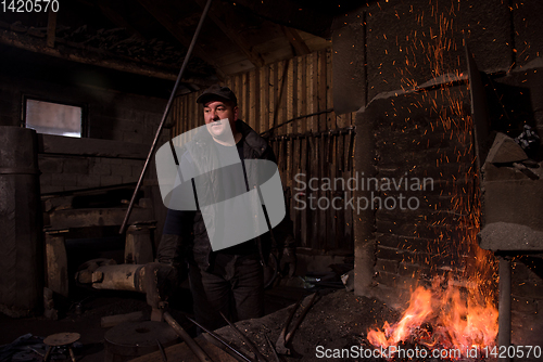 Image of young traditional Blacksmith working with open fire