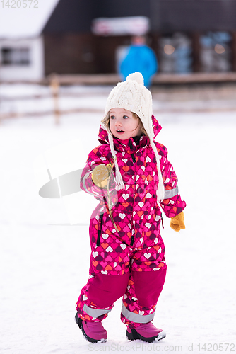 Image of little girl having fun at snowy winter day