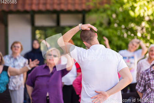 Image of trainer training motivated active healthy senior people