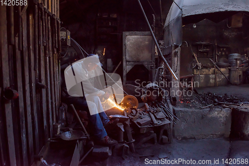 Image of the blacksmith polishing metal products