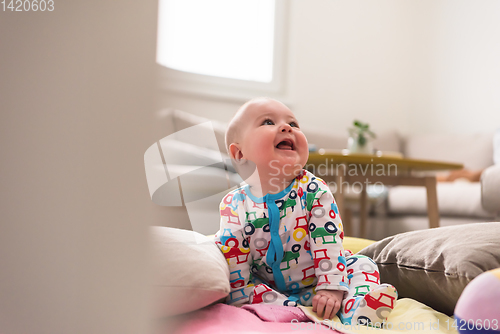 Image of newborn baby boy sitting on colorful blankets