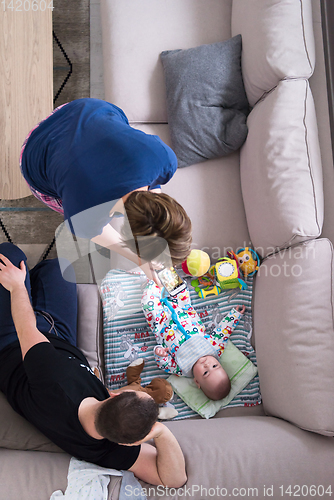 Image of top view of happy mother and father taking picture of baby