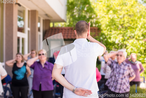 Image of trainer training motivated active healthy senior people