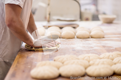 Image of bakery worker preparing the dough
