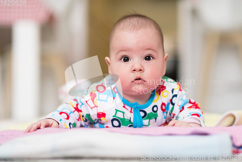 Image of newborn baby boy playing on the floor