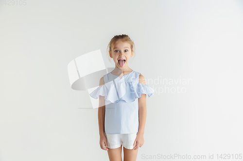 Image of Little smiling girl posing in casual clothes on white studio background