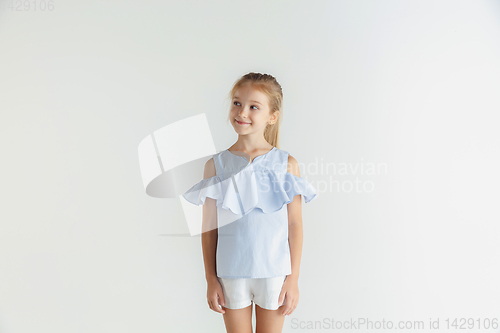 Image of Little smiling girl posing in casual clothes on white studio background