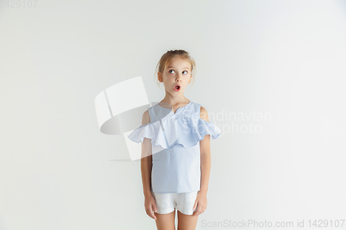 Image of Little smiling girl posing in casual clothes on white studio background