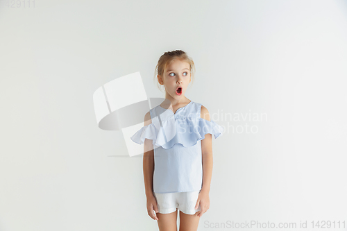 Image of Little smiling girl posing in casual clothes on white studio background