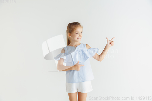Image of Little smiling girl posing in casual clothes on white studio background