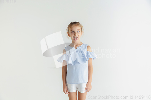 Image of Little smiling girl posing in casual clothes on white studio background