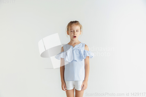 Image of Little smiling girl posing in casual clothes on white studio background