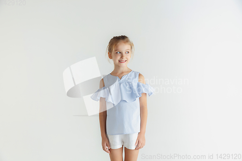 Image of Little smiling girl posing in casual clothes on white studio background