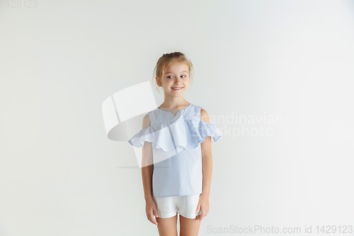 Image of Little smiling girl posing in casual clothes on white studio background