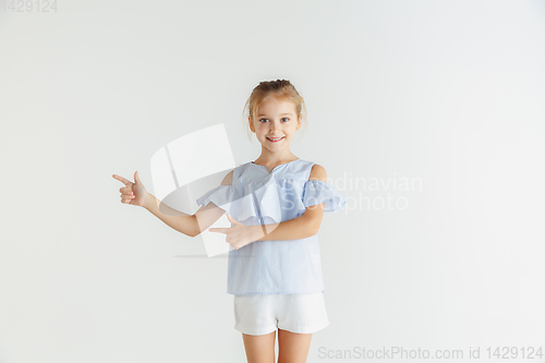 Image of Little smiling girl posing in casual clothes on white studio background